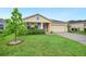 Inviting home with a lush lawn, complemented by a young tree, colorful flowers and a two-car garage at 6819 Glenbrook Dr, Lakeland, FL 33811