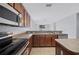 A view of the kitchen features stainless steel appliances and wood cabinets and overlooks the living room at 6819 Glenbrook Dr, Lakeland, FL 33811