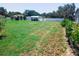 Expansive backyard featuring a lush lawn, white fence, and mature landscaping at 709 N Polk Ave, Fort Meade, FL 33841