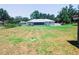Expansive backyard featuring a screened-in lanai, white picket fence, and lush lawn at 709 N Polk Ave, Fort Meade, FL 33841