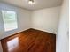 Bedroom with hardwood floors, neutral walls, and natural light from the window at 709 N Polk Ave, Fort Meade, FL 33841