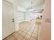 Open-concept entryway with tile flooring that flows into a bright dining area and kitchen with white cabinets at 709 N Polk Ave, Fort Meade, FL 33841