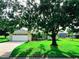Inviting single-story home featuring an attached two-car garage, manicured lawn and mature shade trees at 709 N Polk Ave, Fort Meade, FL 33841
