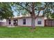 Charming backyard featuring a lush lawn, mature shade trees, and a small outdoor seating area at 7337 Hunters Greene Cir, Lakeland, FL 33810
