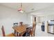 Charming dining area with tile floors, vintage pendant lighting fixture, wooden table, open to kitchen and living room at 7337 Hunters Greene Cir, Lakeland, FL 33810