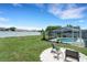 Expansive backyard featuring a screened-in pool, a fire pit area, and lush green grass at 7642 Habersham Dr, Lakeland, FL 33810
