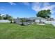 Well-manicured backyard with a screened-in pool, tropical palm trees, and a cozy fire pit area at 7642 Habersham Dr, Lakeland, FL 33810