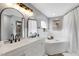 Bright bathroom featuring dual sinks and a large soaking tub with white tile surround and built-in storage at 7642 Habersham Dr, Lakeland, FL 33810