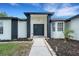 Inviting home entrance with double doors, black brick accents, and manicured landscaping at 7642 Habersham Dr, Lakeland, FL 33810