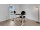 Bright office space with natural light from window, featuring desk and rolling chair on wood-look flooring at 7642 Habersham Dr, Lakeland, FL 33810