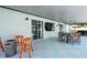 Covered outdoor patio includes dining table and chairs and bar height table with an outdoor grill at 7642 Habersham Dr, Lakeland, FL 33810