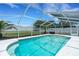 Sparkling pool within a screened enclosure and an adjacent green backyard at 7642 Habersham Dr, Lakeland, FL 33810