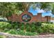 Welcoming entrance to Garden Hills featuring a brick sign with lush greenery and landscaping at 7642 Habersham Dr, Lakeland, FL 33810