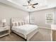 Tranquil main bedroom featuring a tray ceiling, plush carpeting, and abundant natural light from two windows at 827 Cypress Creek Run, St Cloud, FL 34771