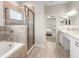 Elegant bathroom featuring a tub, glass-enclosed shower, double sinks, and modern fixtures at 828 Cypress Creek Run, St Cloud, FL 34771