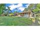 Expansive backyard showcasing a well-manicured lawn, a covered patio, and additional garage at 841 E Valencia St, Lakeland, FL 33805