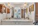Bright bathroom featuring dual sinks, decorative mirrors, and a cabinet for storage at 841 E Valencia St, Lakeland, FL 33805