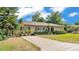 Charming one-story home featuring a well-maintained lawn, mature landscaping, and a long driveway at 841 E Valencia St, Lakeland, FL 33805