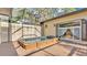 Relaxing outdoor hot tub area with screened enclosure, wood deck, and a tranquil backyard setting at 841 E Valencia St, Lakeland, FL 33805
