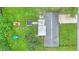 Overhead view of the house with a large backyard, including a covered patio and mature trees at 848 17Th Ne Ter, Winter Haven, FL 33881