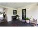 Back porch with a black door, plants, and a rustic wooden chair at 848 17Th Ne Ter, Winter Haven, FL 33881