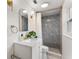 Renovated bathroom with gray tiled shower, modern fixtures, arched mirror and shiplap detail at 848 17Th Ne Ter, Winter Haven, FL 33881