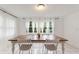 Bright dining room with a wooden table, white chairs, and multiple windows at 848 17Th Ne Ter, Winter Haven, FL 33881
