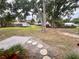 Large backyard with mature trees, a lush lawn, and a patio area, perfect for outdoor activities and relaxation at 8504 N Campbell Rd, Lakeland, FL 33810