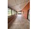 Long screened-in porch featuring tile flooring and a view of the outdoors, perfect for relaxing at 8504 N Campbell Rd, Lakeland, FL 33810