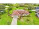 Aerial view of a home featuring a large yard, covered pool, mature landscaping, and a driveway at 8535 Plantation Ridge Blvd, Lakeland, FL 33809