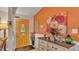 Bright foyer with an ornate yellow door, a decorative dresser, and colorful floral artwork at 8535 Plantation Ridge Blvd, Lakeland, FL 33809
