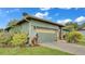 Attached two-car garage with an automatic door, landscaping, and easy access to the home at 8535 Plantation Ridge Blvd, Lakeland, FL 33809