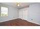 Comfortable bedroom with hardwood floors, white trim, window and double closet at 943 Hamilton Place Ln, Lakeland, FL 33813