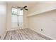 Bright bedroom features a ceiling fan, large window, and wood-look floors at 943 Hamilton Place Ln, Lakeland, FL 33813