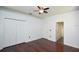 Neutral bedroom with hardwood floors, a ceiling fan, and two closets at 943 Hamilton Place Ln, Lakeland, FL 33813