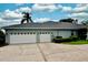 House with a three-car garage and a well-manicured lawn at 943 Hamilton Place Ln, Lakeland, FL 33813