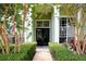 Home's entryway features a pathway to a black double-door entry and manicured landscaping at 943 Hamilton Place Ln, Lakeland, FL 33813