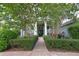 View of the front entrance framed by hedges and mature trees at 943 Hamilton Place Ln, Lakeland, FL 33813
