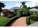 Landscaped front yard featuring mature trees, manicured hedges and a circular driveway leading to the home at 943 Hamilton Place Ln, Lakeland, FL 33813
