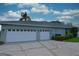 Three-car garage and side view of the house with blue skies at 943 Hamilton Place Ln, Lakeland, FL 33813