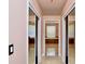 Hallway view leading to bright bathroom with large soaking tub and neutral tile flooring at 943 Hamilton Place Ln, Lakeland, FL 33813