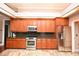 Gourmet kitchen featuring stainless steel appliances, granite countertops, and wood cabinets at 943 Hamilton Place Ln, Lakeland, FL 33813