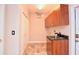 Functional laundry area features wooden cabinets, utility sink, and tiled floors at 943 Hamilton Place Ln, Lakeland, FL 33813