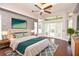 A luxurious main bedroom showcasing a decorative ceiling fan, hardwood floors, and a king-size bed at 943 Hamilton Place Ln, Lakeland, FL 33813