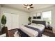 This primary bedroom has hardwood floors, a gray upholstered bed, and closet at 943 Hamilton Place Ln, Lakeland, FL 33813