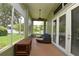 Inviting sunroom with brick floors and comfortable seating, offering serene views of the lush backyard at 943 Hamilton Place Ln, Lakeland, FL 33813