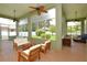 Relaxing sunroom featuring brick floors, ceiling fans, and comfortable seating with backyard views at 943 Hamilton Place Ln, Lakeland, FL 33813