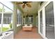 Screened-in patio featuring comfortable outdoor seating, ceiling fans, and brick flooring at 943 Hamilton Place Ln, Lakeland, FL 33813