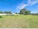 Spacious backyard with green grass, shade tree, above ground pool and white fence at 1034 Shadowbrook N Dr, Lakeland, FL 33813