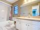 Bathroom featuring a shower/tub with a curtain and vanity with white cabinets and a large mirror at 1034 Shadowbrook N Dr, Lakeland, FL 33813